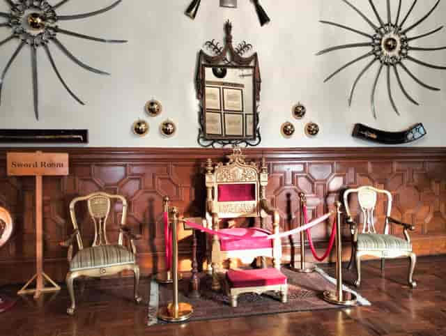 Dining room with ornate throne, ideal for exclusive historical events and gatherings.