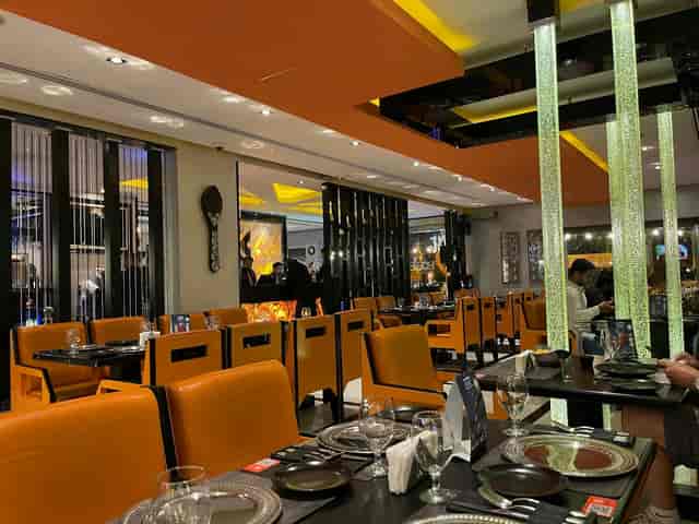 Modern Karachi Grill Restaurant interior with vibrant orange seating, ideal for events.