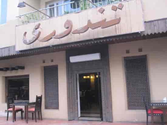 "Inviting Tandoori restaurant entrance with rustic decor for casual meetings and events."