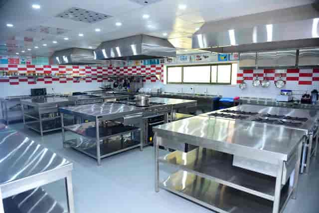 Modern commercial kitchen with stainless steel for culinary workshops and events.