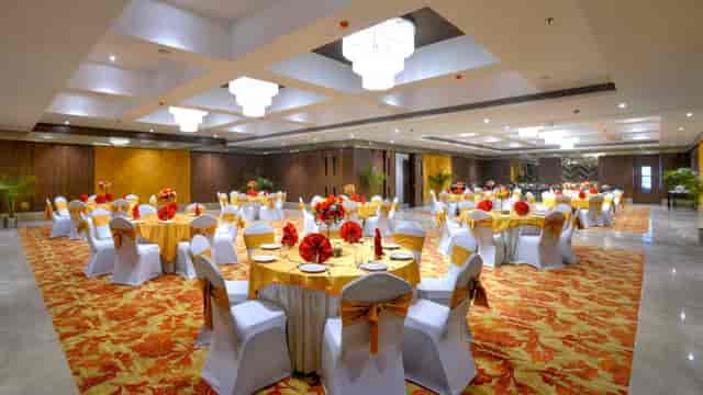 Banquet Hall at Golden Tulip Srinagar, elegant wedding venue with yellow tablecloths.