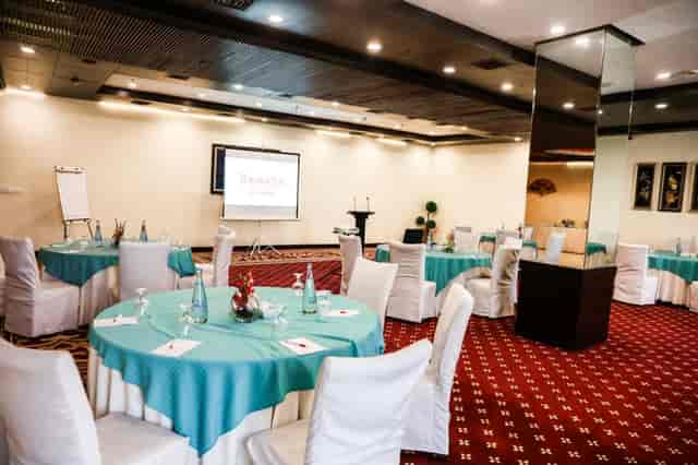 Kehkashan Hall conference room with teal tables and projector for events in Islamabad.