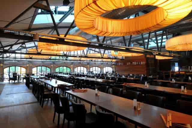 Spacious restaurant dining area with communal tables, perfect for networking events.