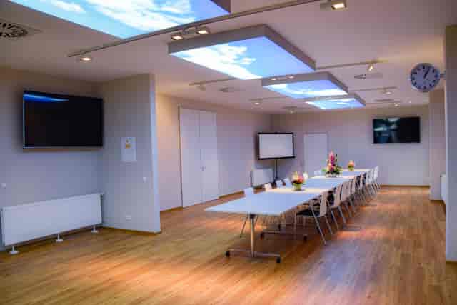 Modern meeting room with long table, ideal for conferences and presentations.