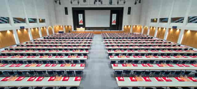 Spacious lecture hall with red placemats, perfect for professional seminars and conferences.