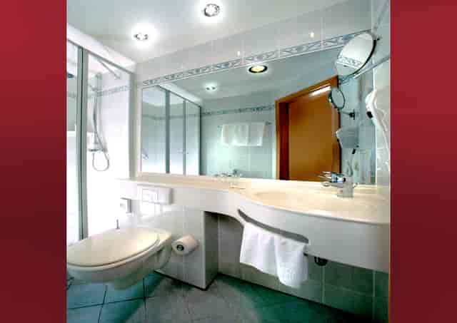 Modern restroom in Hotel Kurhaus Ochs with sleek fixtures for events and meetings.