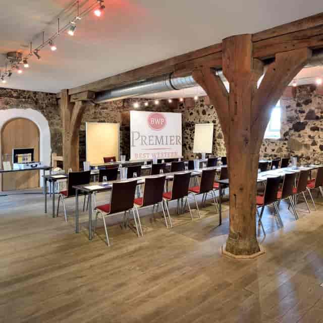 Meeting room with natural lighting and wooden beams for workshops at Villa Stokkum.