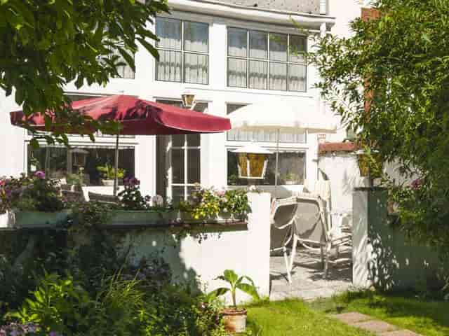 Charming outdoor garden venue with seating for receptions and networking events.