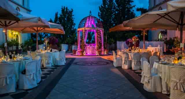 Outdoor wedding venue at Villa il Poggione with elegant tables and floral canopy.