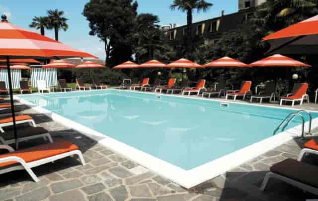 Outdoor pool at Hotel Villa Paradiso with orange umbrellas, ideal for events and gatherings.