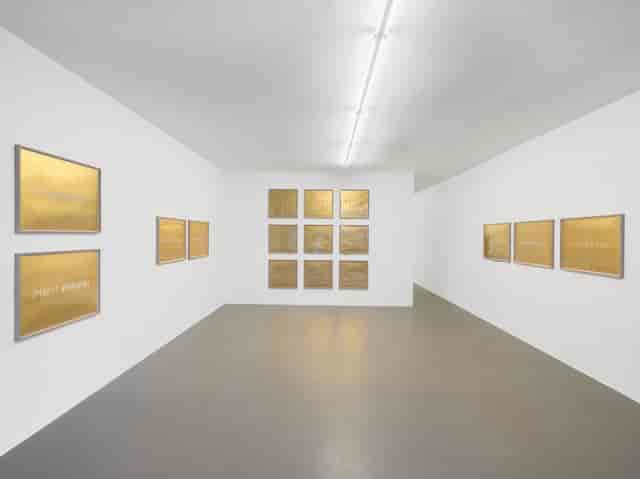 Minimalist gallery space with golden artwork, ideal for art receptions and corporate events.
