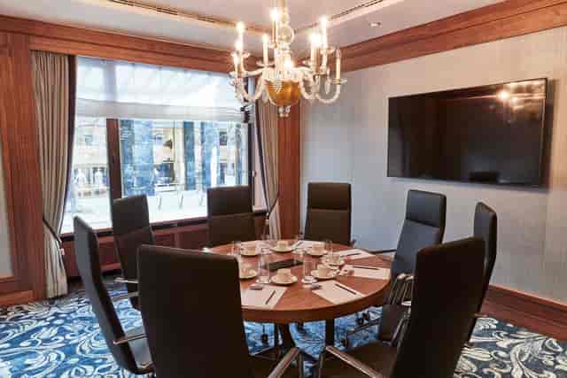 Grüner Salon meeting room with round table, chandelier, ideal for conferences and events.