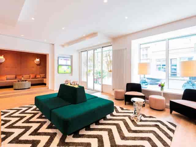 Modern event space in ibis Styles Frankfurt with vibrant green seating, ideal for conferences.