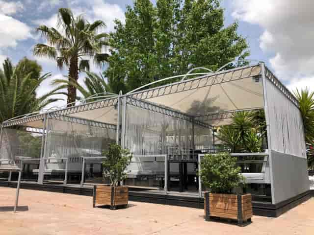 Outdoor lounge at Fabrik Club, featuring lush greenery for stylish events and gatherings.