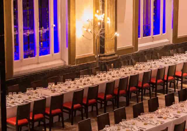 Elegant product launch dinner setup in Spathios Madrid with stylish red seating.