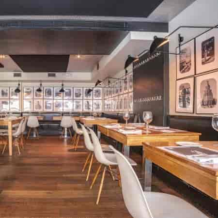 Sangria Bar dining area with wooden tables, ideal for intimate dinners and events.