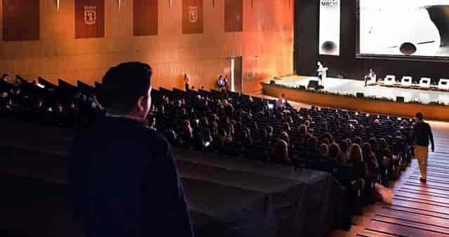 Large auditorium at Palacio Municipal set for a conference with engaged audience.