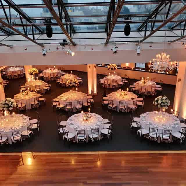 Elegant networking and tasting event in Luxe Loft Venue with round tables and floral centerpieces.