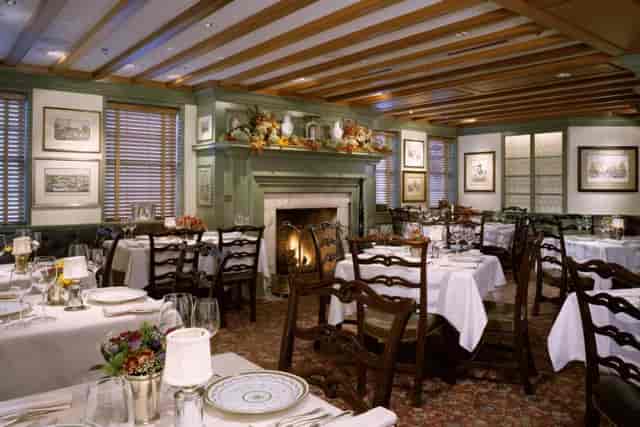 Elegant dining room with fireplace at Wickets Room, ideal for intimate events and gatherings.