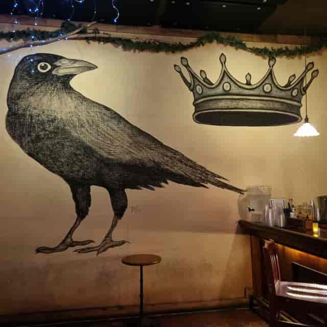 Live music bar The Crown & Crow with striking crow mural, perfect for events.