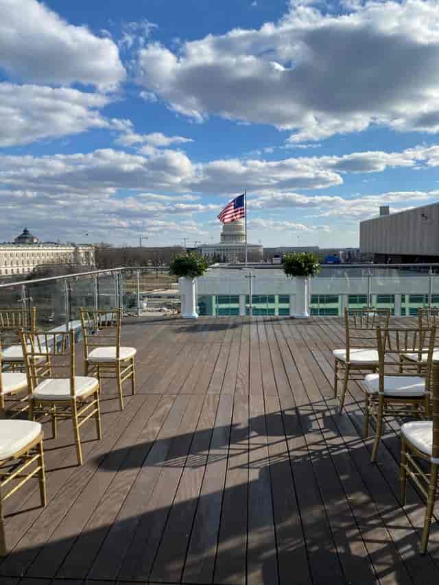 Elegant rooftop event space with gold chairs, U.S. Capitol backdrop, perfect for gatherings.