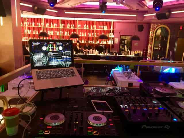 Vibrant meeting space with DJ station and stylish bar for events and celebrations.
