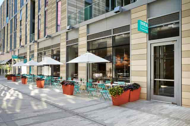 Modern outdoor seating at Osteria in Centrolina with turquoise tables for events.