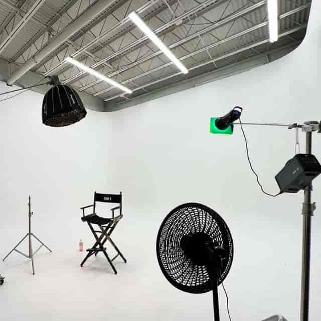 Producer's meeting in minimalist studio with white backdrop for filming and live events.