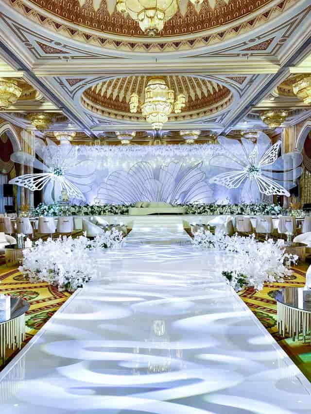Elegant wedding setup in Grand Ballroom, InterContinental Abu Dhabi, with floral backdrop.