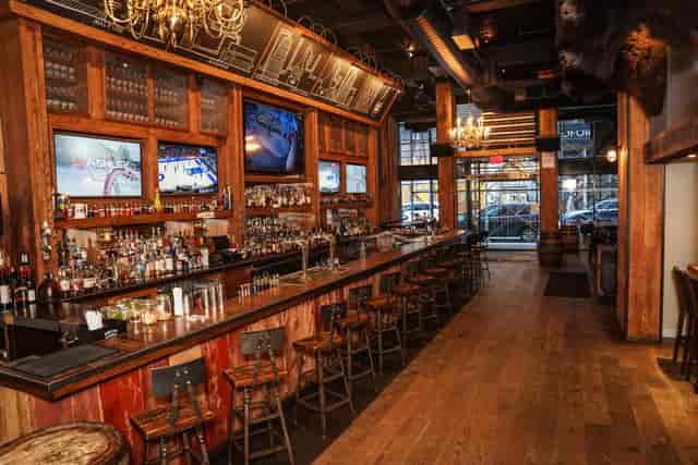 Stylish American Whiskey Midtown bar with rich wood tones, ideal for networking events.