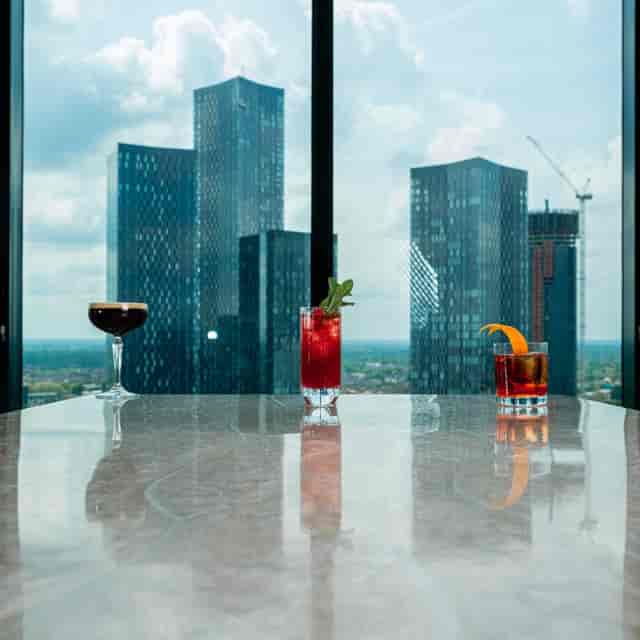 Sleek cocktail setup with vibrant drinks and city skyline, ideal for corporate events.