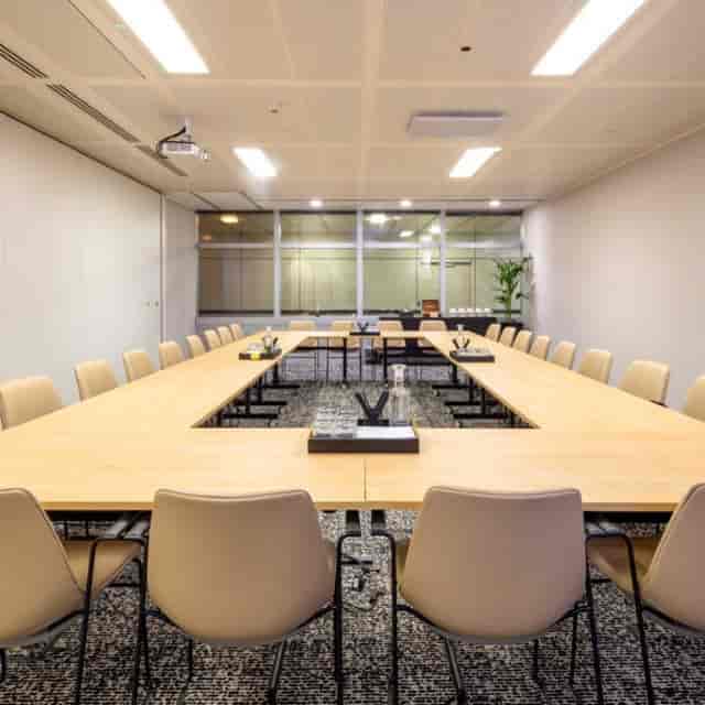 Modern conference room with large table, ideal for meetings and workshops.