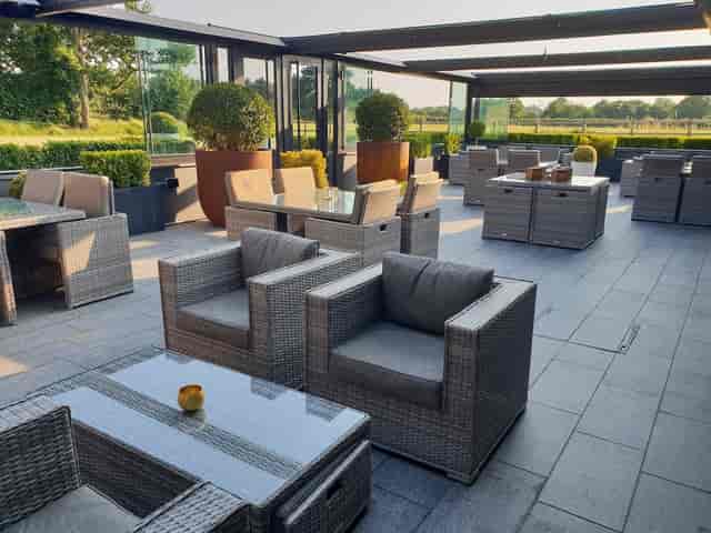 Elegant outdoor business meeting space with wicker seating for networking events.