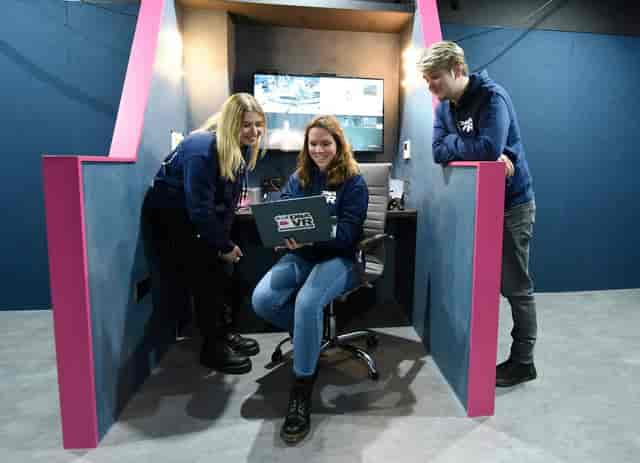 VR arcade booth with professionals showcasing interactive technology at an event.