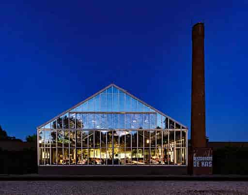 "Modern glass restaurant De Kas, ideal for events with vibrant ambiance and natural elements."