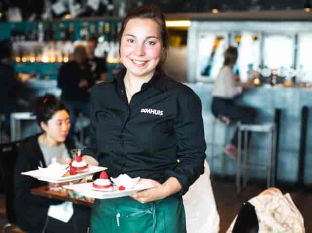Server presenting desserts at BIMHUIS cafe, perfect for upscale events and gatherings.
