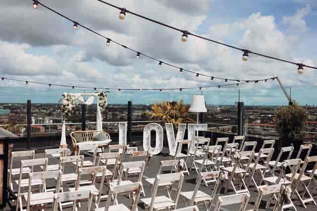 Skybar venue with string lights, white chairs for weddings and special events.