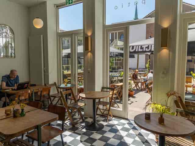 Light-filled café patio with outdoor seating for casual meetings and networking events.