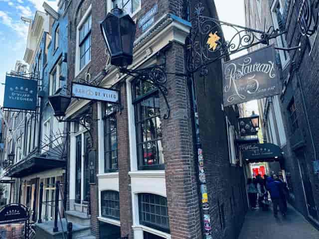 Charming alley entrance at Restaurant d'Vijff Vlieghen for unique dining events, Amsterdam.