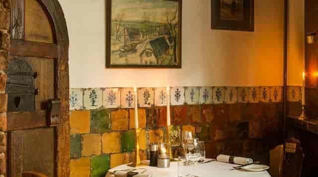 Cozy dining setting in Glass Room, d'Vijff Vlieghen, ideal for intimate celebrations and corporate dinners.