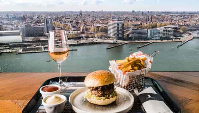 Terrace bar at Art Hotel Amsterdam with gourmet burger, fries, and city views for events.