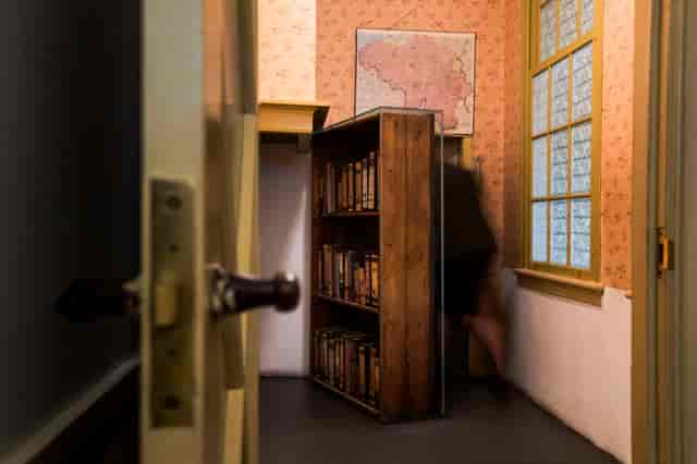 "Anne Frank House exhibition hall with hidden bookshelf door for unique event experiences."