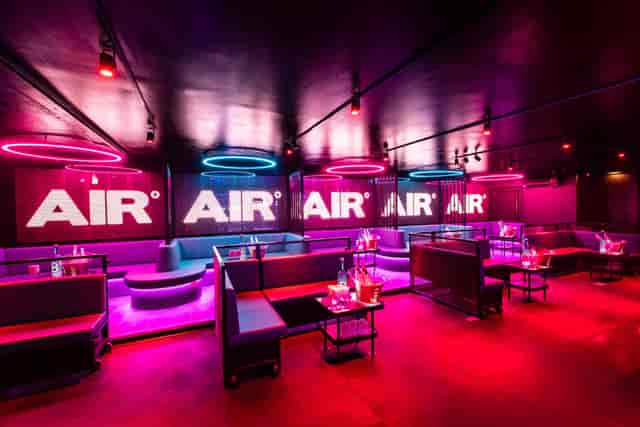 Modern event space in Amsterdam with vibrant neon lighting for social gatherings.