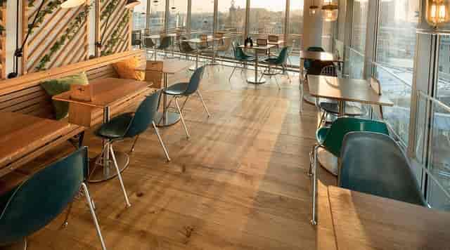Bright event space in Blue Amsterdam with wooden flooring for networking and meetings.