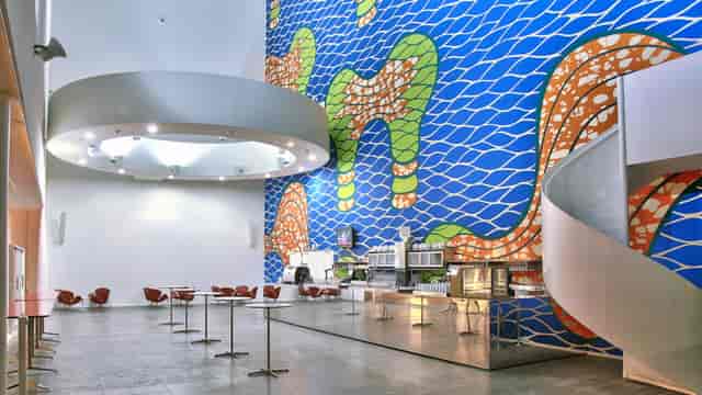 Modern event space with vibrant mural, ideal for dynamic workshops and social gatherings.