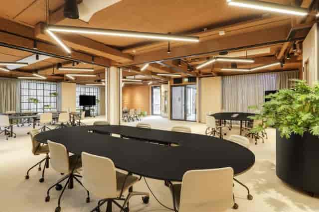 Modern meeting room at Omnia Retail, showcasing round tables, ideal for events and collaboration.