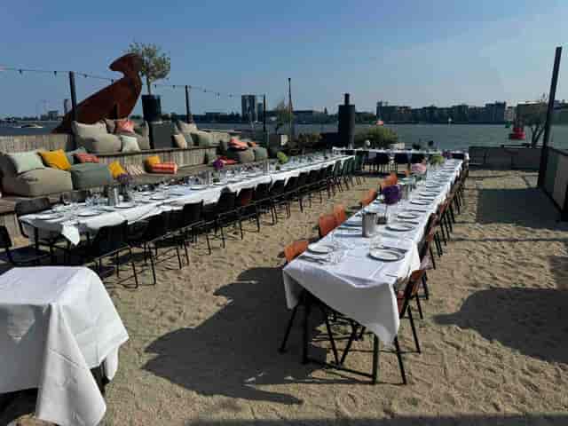Outdoor banquet space in Hangar Amsterdam with elegant table by the waterfront.