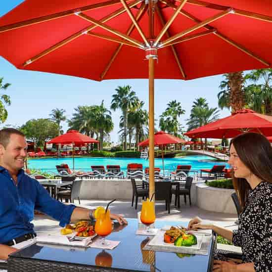 Horizon Garden outdoor dining setup with red umbrellas for networking events and casual gatherings.