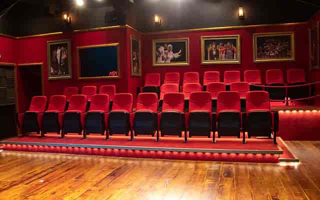 Intimate performing arts theater with red seating, ideal for workshops and presentations.