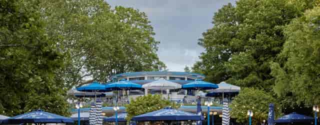 "Outdoor event venue at Proeflokaal 't Blauwe Theehuis with greenery and blue umbrellas."